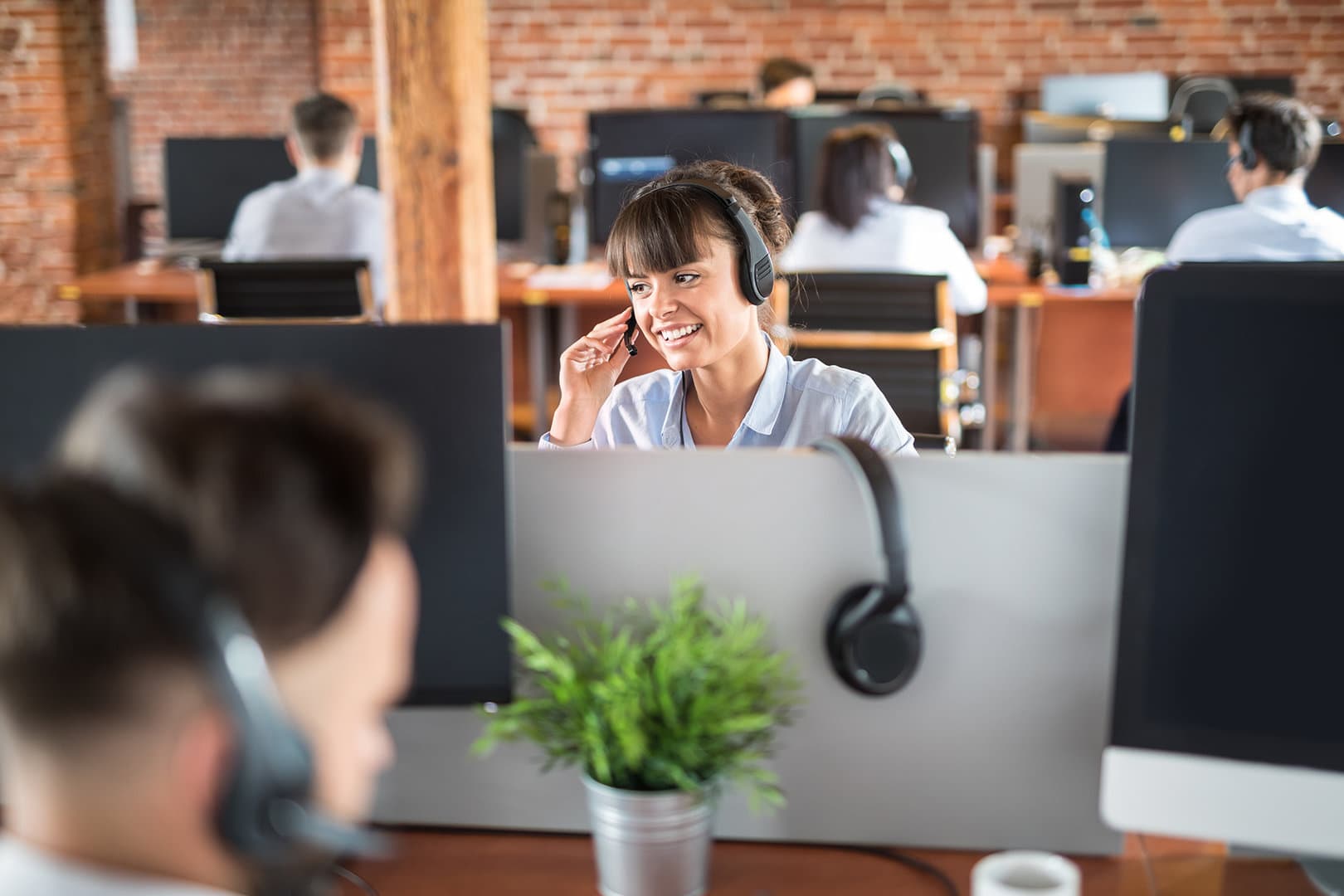 Woman in call center speaking on headset.